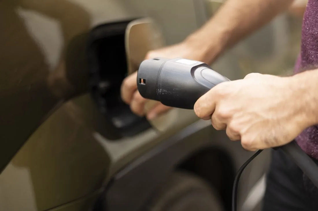 Ladestecker wird in ein Elektrofahrzeug gesteckt